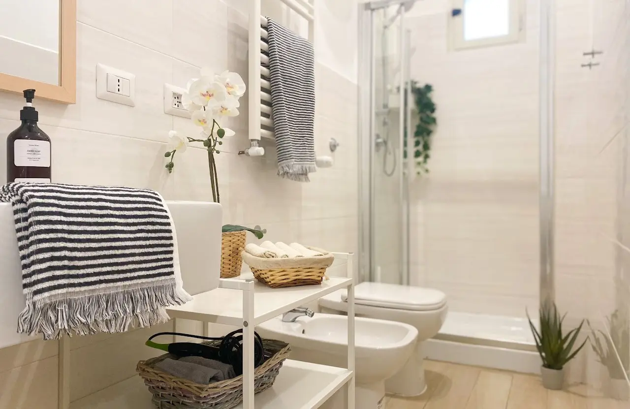 Seconda vista del bagno con doccia e dettagli essenziali