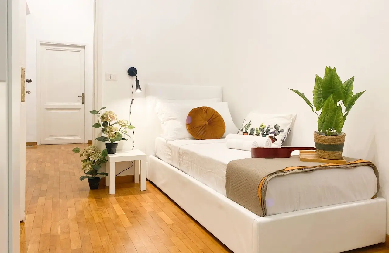 Dettaglio di una camera singola con letto e comodino